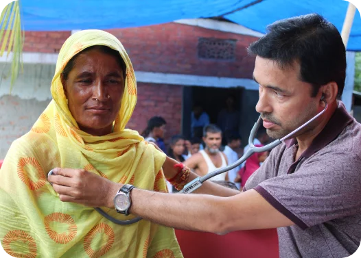 A healthcare worker is using a stethoscope on a patient outdoors.