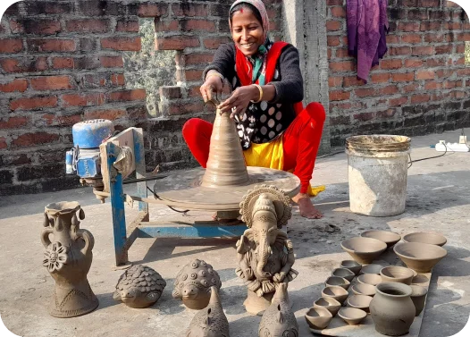 Person shaping pottery on a wheel with various clay pieces nearby.